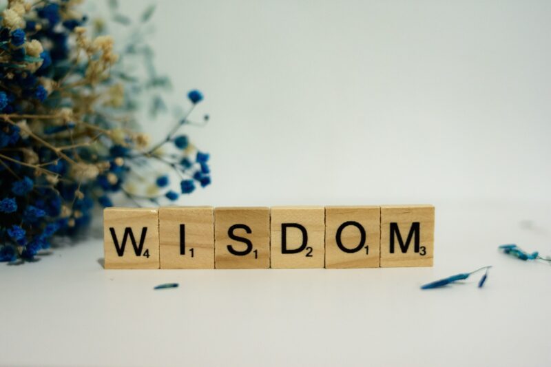 Game piece tiles spelling out the word 'Wisdom' on a tabletop